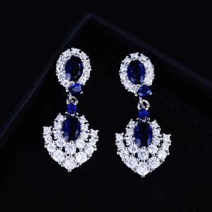 Macro detail of royal blue sapphire drop earrings set in elegant black velvet jewelry box
