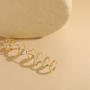Set of five gold adjustable ear cuffs featuring pink and clear zircon in various designs