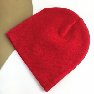 Close-up of bright red knitted beanie showing detailed yarn texture and craftsmanship