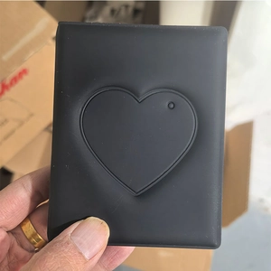 Detail of hand holding a black heart cutout photocard holder made of soft material