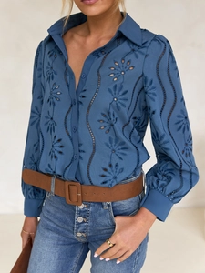 Close-up of blue hollow out floral embroidery and button details on woman cardigan