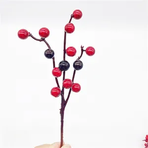 Detailed view of glossy red and dark purple artificial berry stems for Christmas DIY decor