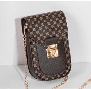Detail view of small square crossbody bag featuring brown clover pattern and heart lock
