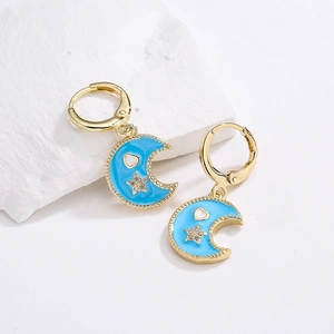 Gold plated hoop earrings with light blue enamel moon and star charms and zircon stones