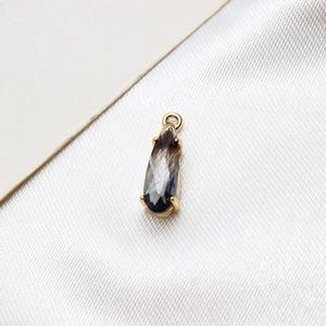 Macro detail of a teardrop crystal charm with a gold-plated base for DIY jewelry