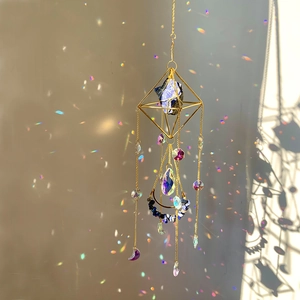 Detail of crystal sun catcher with blue stone casting colorful rainbows on wall