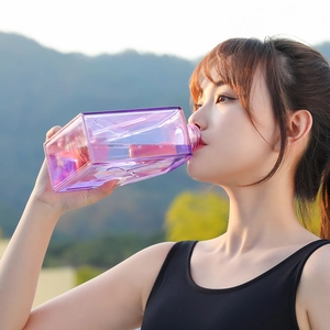 Purple transparent square sports water bottle for fitness with outdoor mountain background