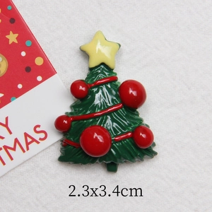 Détail macro d'un accessoire sapin de Noël en résine pailleté avec émail vert 2,3x3,4cm