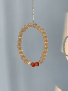 Detail showing natural brown cat-eye agate beads on a vertical silver chain