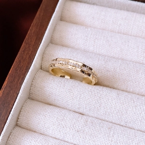 Detail of 14K gold plated ring with textured lava finish and sparkling zircon stones