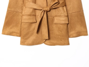 Dettaglio di un blazer scamosciato color cammello con cintura in vita e tasche a patta