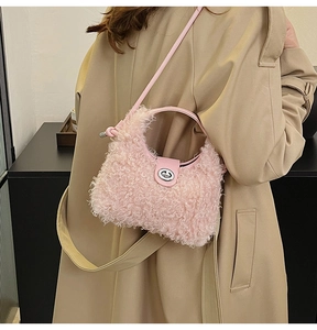 Detailed close-up of a pink teddy faux fur handbag with a metal twist lock and leather strap