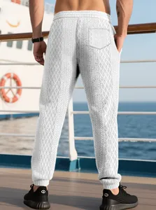 Detail of men's white joggers featuring dark grey geometric diamond knit texture pattern