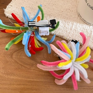 Detail of multi-color LED plush hair clip showing the back mechanism and switch
