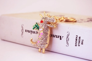 Détail d'un porte-clés dragon doré orné de strass brillants et de finitions en émail coloré