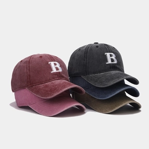 Close-up of vintage washed cotton baseball caps with embroidered letter B and 6-panel design