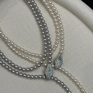 Elegant double-layer pearl necklace featuring a diamond-studded snake head pendant