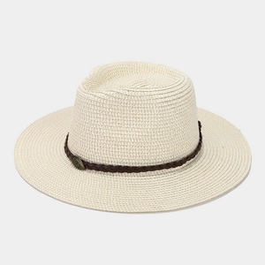 Close-up of cream woven straw fedora featuring a brown leather band and vintage metal emblem