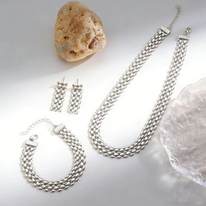Close-up of minimalist pebble link jewelry set with necklace, bracelet and earrings