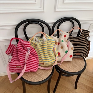 Detailed view of four colorful striped plush tote bags with detachable shoulder straps