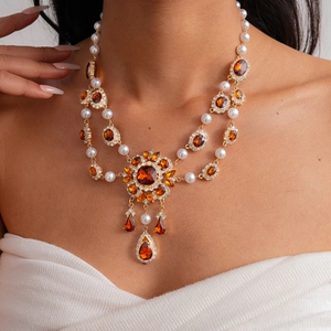 Baroque style pearl necklace with amber crystals and gold floral sun pendant detail