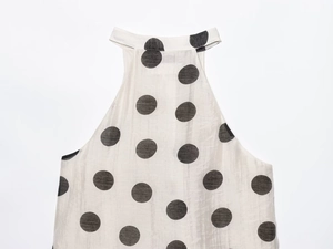 Detailed shot of white halter top with large black polka dots in premium light fabric