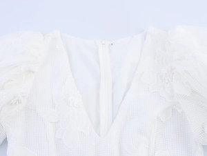 Detail of the invisible back zipper and floral lace mesh embroidery on white dress