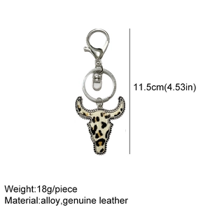 Detailed view of leopard print leather bull head keychain with silver alloy hardware