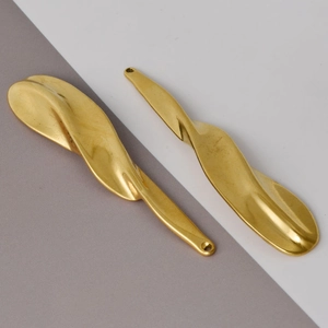 Close-up of golden irregular wavy pendants in 304 stainless steel with organic twisted shape