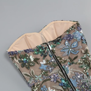 Close-up of floral embroidery with colorful sequins and silver zipper on mesh dress