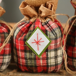 Close-up of Christmas burlap gift bag featuring a star patch and red plaid pattern