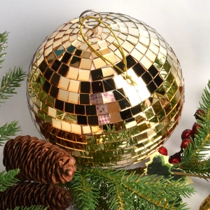 Golden mirror disco ball Christmas ornament with pine cones and festive red berries decorations