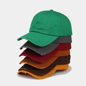 Detailed view of washed distressed baseball caps in various colors with worn edge details
