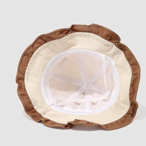 Detail view of baby sun hat with wavy brim, contrast colors, and secure cotton chin strap