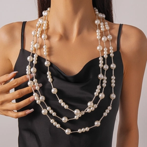 Détail d'un collier de perles à trois rangs avec accents argentés sur robe noire