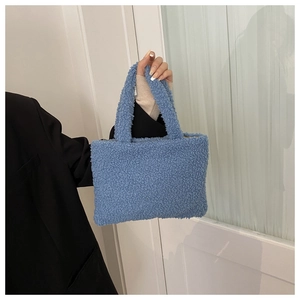Blue fuzzy plush handbag for women with dual top handles shown in a lifestyle setting
