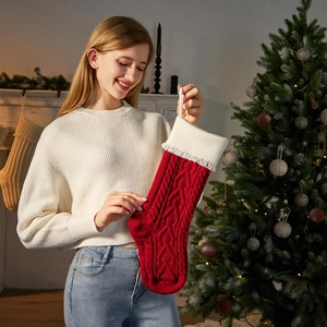 Classic red and white cable knit Christmas stocking with festive tassels and soft plush cuff