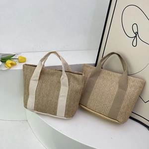 Close-up of minimalist straw tote bags with fabric handles in beige and khaki tones