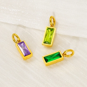 Three gold stainless steel rectangular pendants with colorful birthstones on white fabric