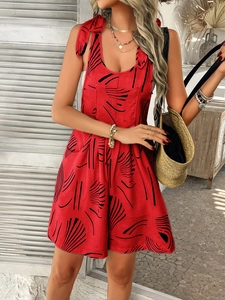 Detail of red floral romper with black abstract patterns and shoulder ties for summer style