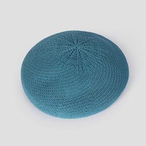 Close-up of knit beret featuring fine crochet texture and round top design in teal