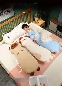 Detail view of soft animal plush long pillows in cat and dog shapes on a cozy bed