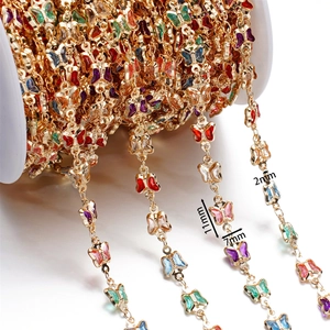 Macro detail of 11x7mm colorful enamel butterfly charms on gold plated jewelry chain