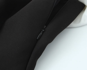 Détail de la fermeture éclair invisible sur une robe mi-longue noire et blanche de style français