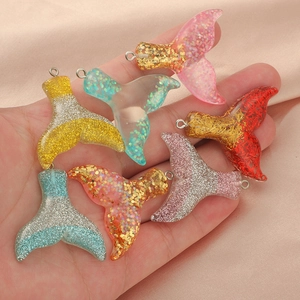 Sparkly resin mermaid tail pendants with colorful sequins in various gradient colors