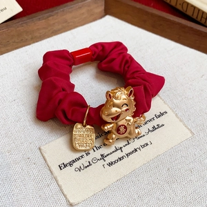Détail macro du chouchou rouge avec pendentif dragon doré et caractère festif chinois