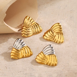 Boucles d'oreilles triangulaires géométriques minimalistes en or et argent sur fond texturé