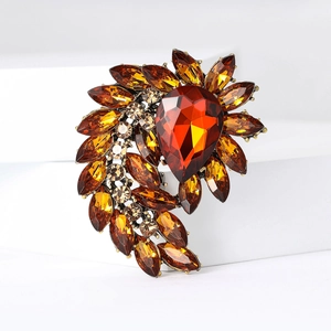 Detail shot of vintage bronze brooch with large pear-cut amber crystal and marquise rhinestones