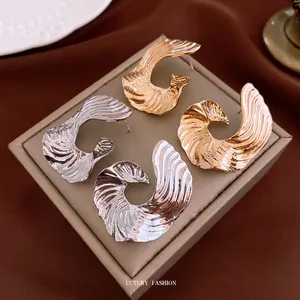 Exaggerated geometric C-shape textured metal earrings in gold and silver finish