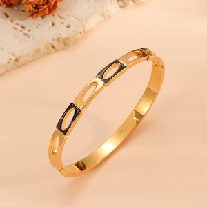 Vue détaillée à 45 degrés d'un bracelet ajouré doré en forme de cœur avec émail noir élégant
